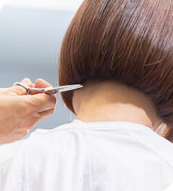 襟足の髪を切り揃えてもらっている女性の画像 